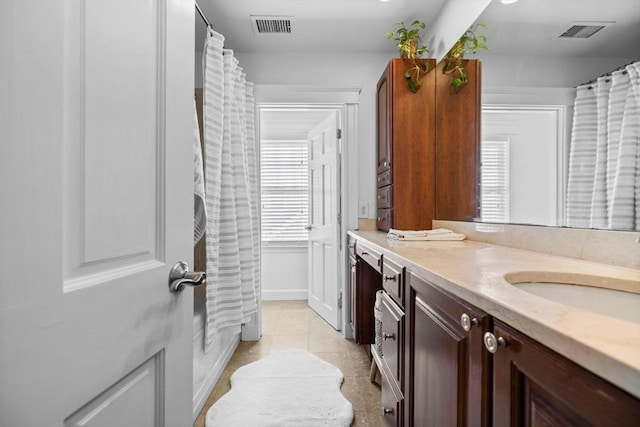 bathroom featuring tile patterned floors, visible vents, shower / tub combo with curtain, and vanity