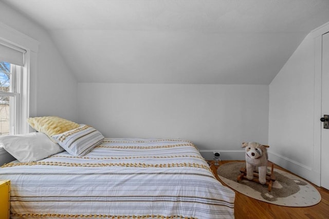 bedroom with lofted ceiling, baseboards, and wood finished floors