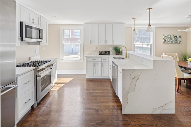 kitchen featuring pendant lighting, appliances with stainless steel finishes, white cabinets, and dark wood-type flooring