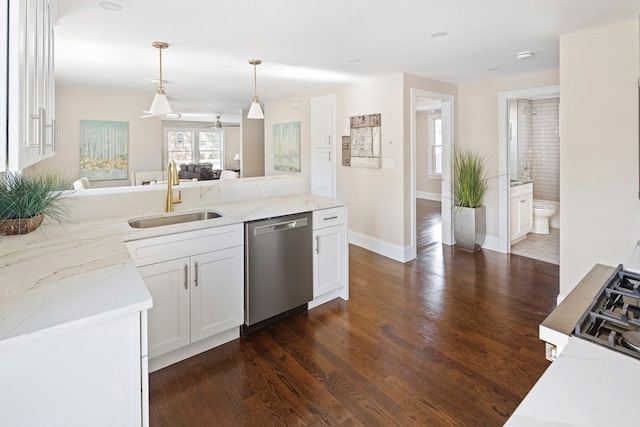 kitchen featuring dark wood-type flooring, light stone countertops, dishwasher, and sink