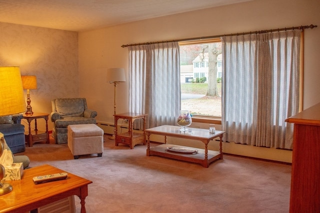 sitting room with a baseboard heating unit and carpet flooring