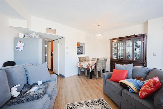 living room with an inviting chandelier and light hardwood / wood-style floors