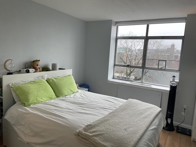 bedroom featuring baseboards and wood finished floors