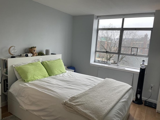 bedroom with wood finished floors and baseboards