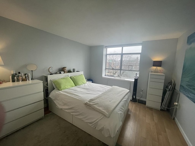 bedroom featuring baseboards and light wood finished floors