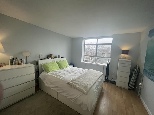 bedroom with wood finished floors and baseboards