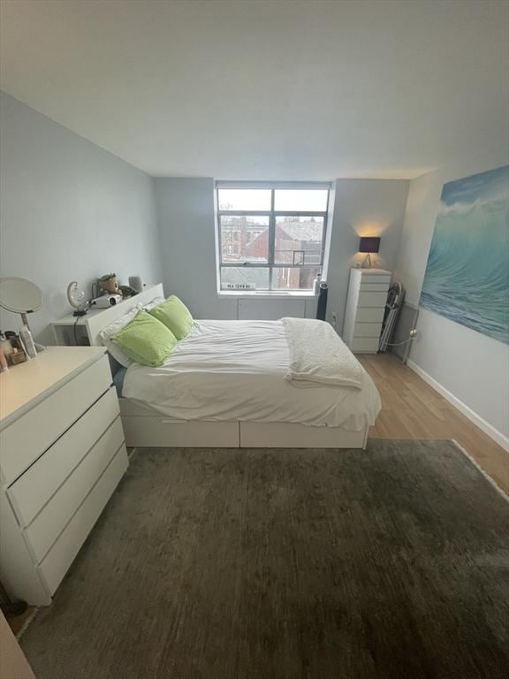 bedroom featuring baseboards and light wood finished floors