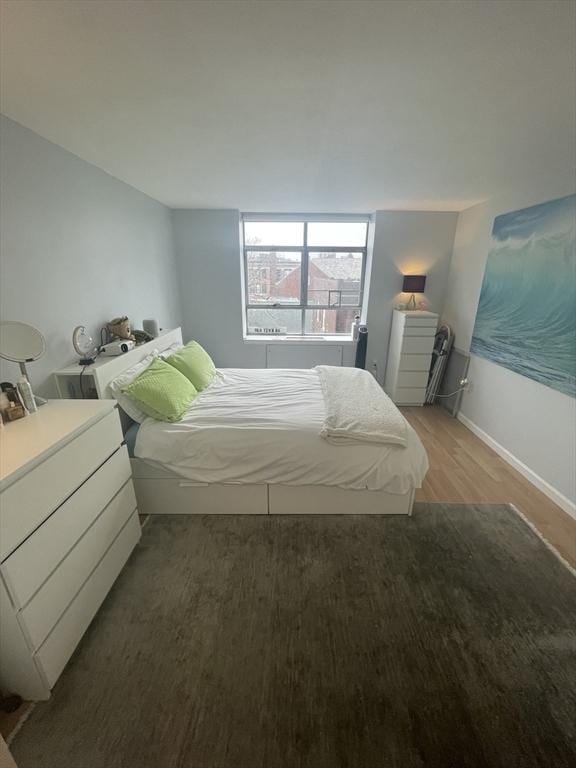 bedroom with wood finished floors and baseboards