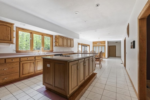 27 Sullivan Blvd, Oxford, MA 01540 - kitchen with a sink, light tile patterned floors, a center island, brown cabinets, and recessed lighting