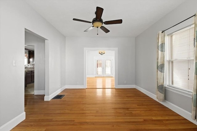 unfurnished room with light wood-type flooring, ceiling fan, and a wealth of natural light