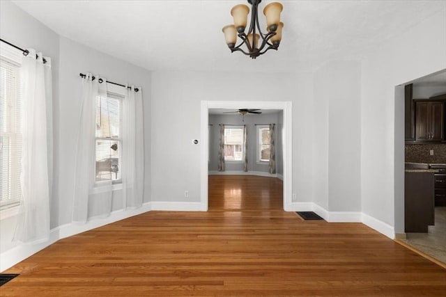 unfurnished dining area with hardwood / wood-style flooring and a chandelier