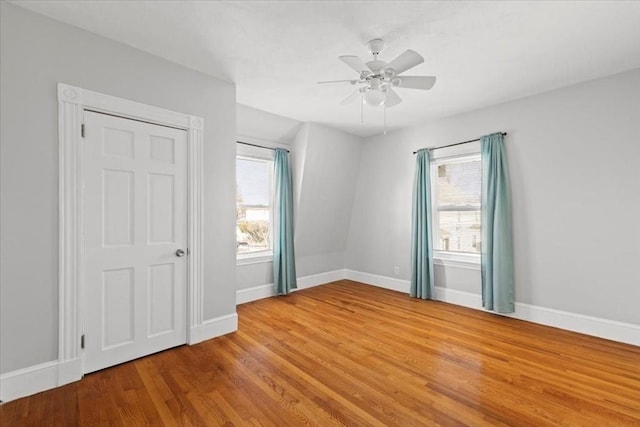 empty room with ceiling fan and light hardwood / wood-style floors