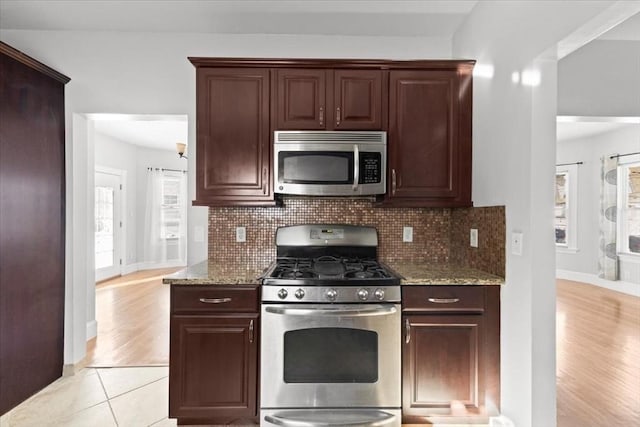 kitchen featuring light stone counters, appliances with stainless steel finishes, plenty of natural light, and tasteful backsplash