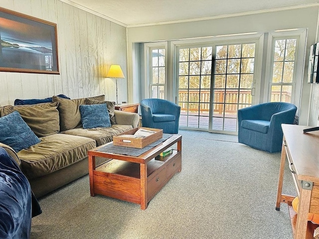 living room featuring light carpet, wooden walls, plenty of natural light, and crown molding