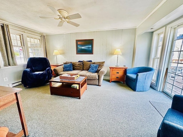 carpeted living area with a ceiling fan, a baseboard radiator, and crown molding