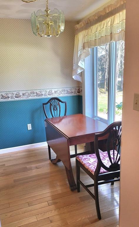 15 Iris Way Unit 27, Haverhill, MA 01830 - dining room with wallpapered walls, a chandelier, light wood finished floors, baseboards, and a wainscoted wall