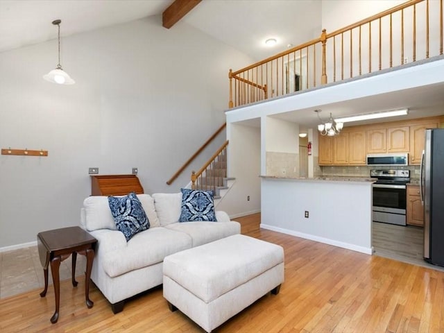 44 Casablanca Ct Unit 44, Haverhill, MA 01832 - living area with high vaulted ceiling, beamed ceiling, light wood finished floors, stairs, and baseboards