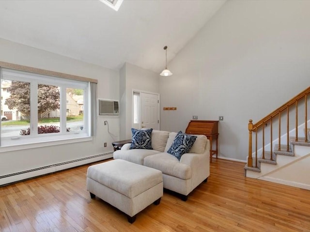 44 Casablanca Ct Unit 44, Haverhill, MA 01832 - living area featuring light wood-style floors, a baseboard radiator, a wall unit AC, high vaulted ceiling, and stairway