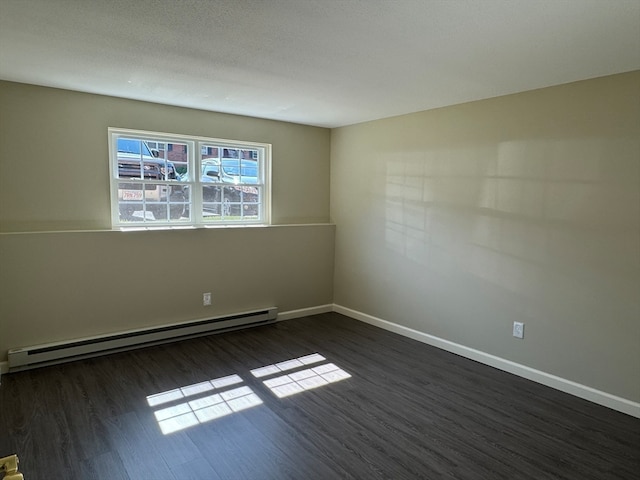 empty room with a textured ceiling, dark wood-type flooring, and a baseboard radiator