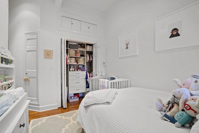 bedroom with light hardwood / wood-style floors and a closet