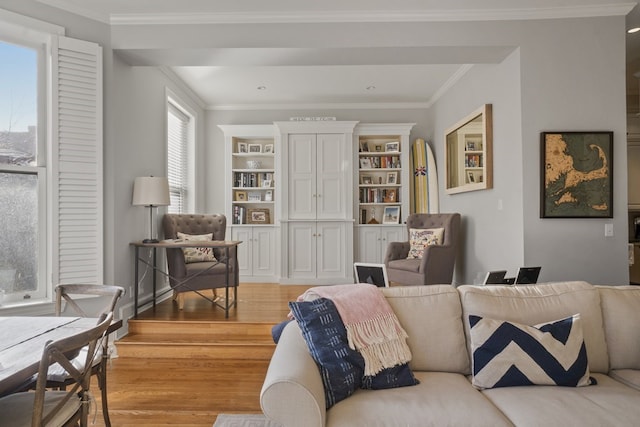 living room with light hardwood / wood-style floors, built in features, and crown molding