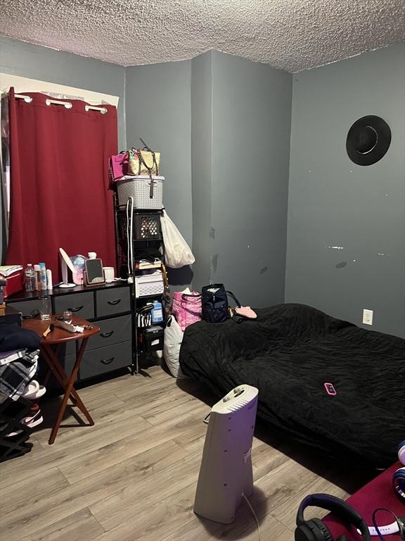 bedroom with a textured ceiling and light wood-type flooring