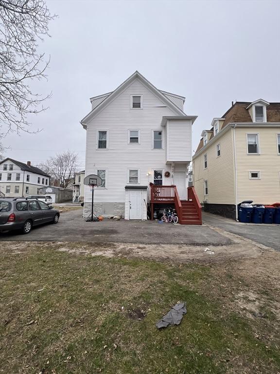 rear view of property featuring a lawn