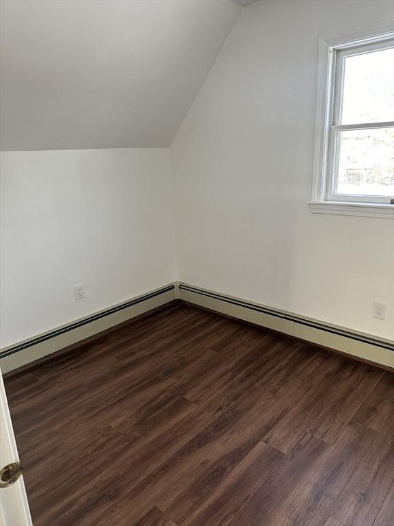 bonus room with vaulted ceiling and dark wood-type flooring