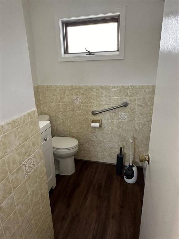 bathroom featuring hardwood / wood-style flooring, tile walls, and toilet