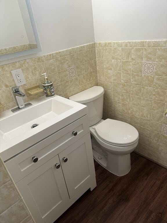 bathroom featuring vanity, wood-type flooring, tile walls, and toilet