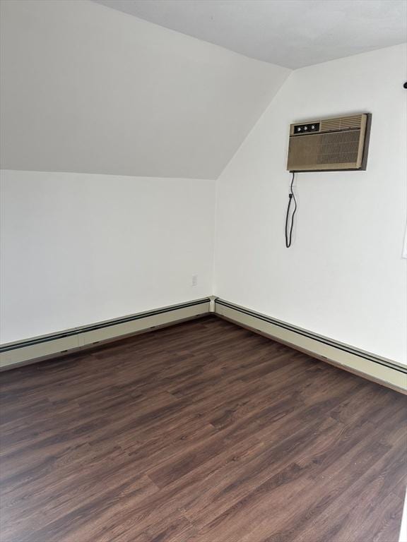 bonus room with vaulted ceiling, an AC wall unit, and dark hardwood / wood-style flooring