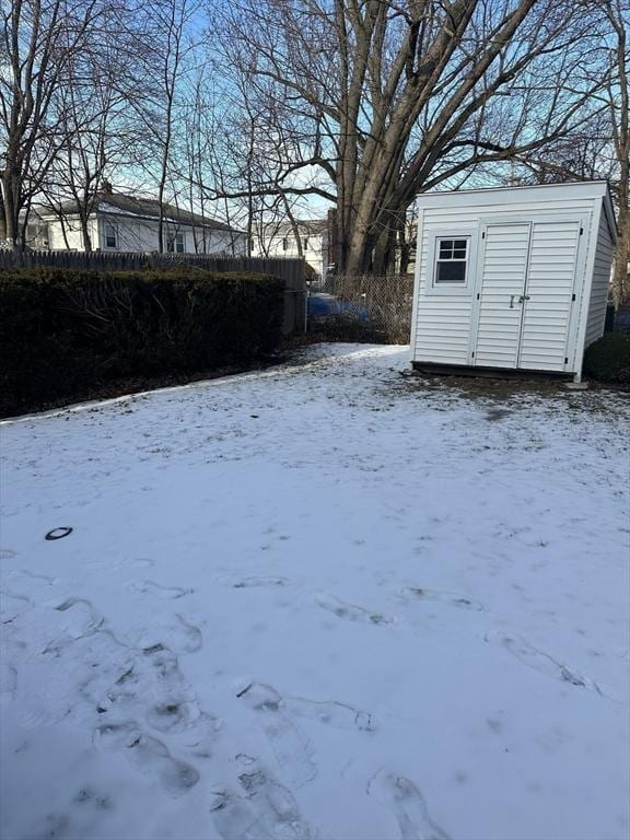 snowy yard with a storage unit