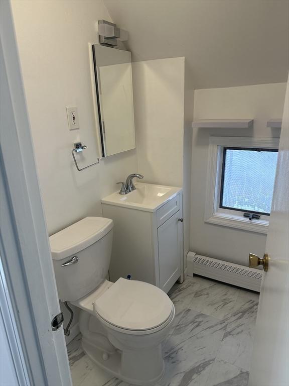 bathroom featuring vanity, toilet, and baseboard heating