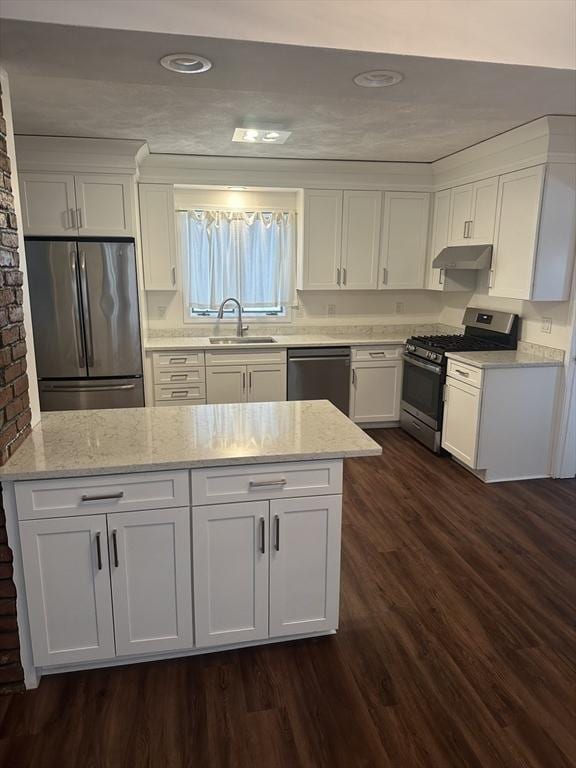 kitchen featuring white cabinetry, light stone counters, stainless steel appliances, and dark hardwood / wood-style floors