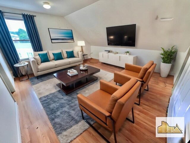 living room featuring lofted ceiling and wood finished floors