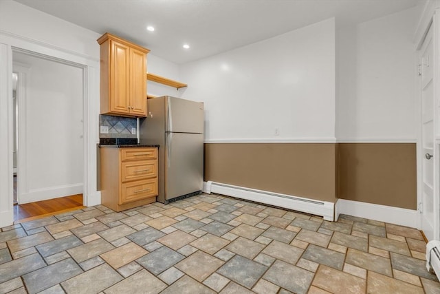 kitchen featuring stainless steel fridge, light brown cabinets, baseboard heating, and backsplash