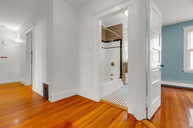 hallway featuring hardwood / wood-style flooring and a baseboard radiator