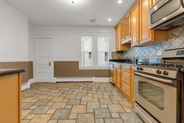 kitchen featuring appliances with stainless steel finishes, a baseboard radiator, tasteful backsplash, and sink