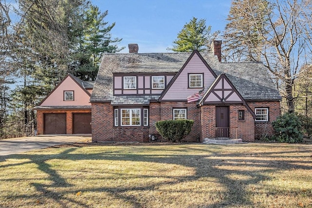 tudor house with a garage and a front lawn