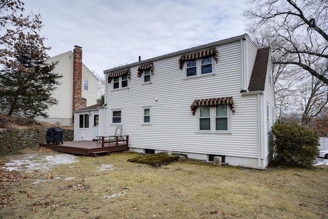 back of house with a deck and a lawn