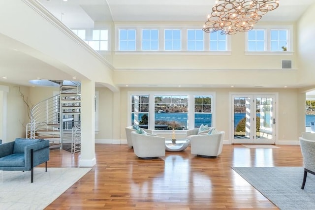 living area with baseboards, visible vents, and wood finished floors