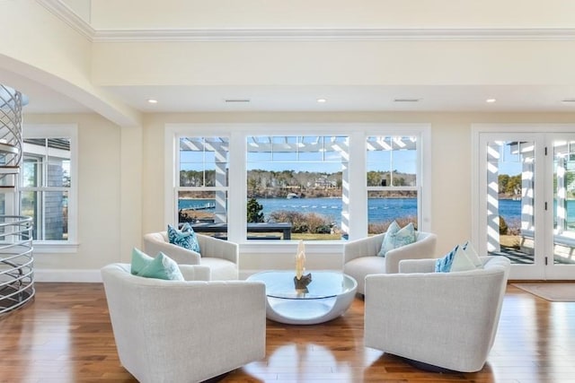 living area with hardwood / wood-style floors, a wealth of natural light, and baseboards