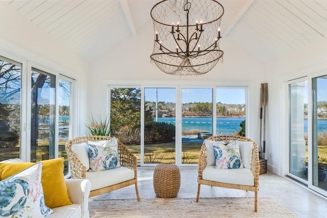 sunroom featuring vaulted ceiling with beams, an inviting chandelier, a water view, and a wealth of natural light