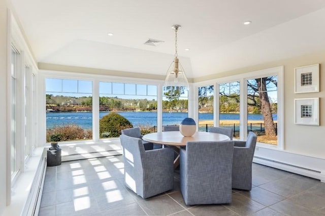 sunroom with a healthy amount of sunlight, a water view, a baseboard radiator, and visible vents