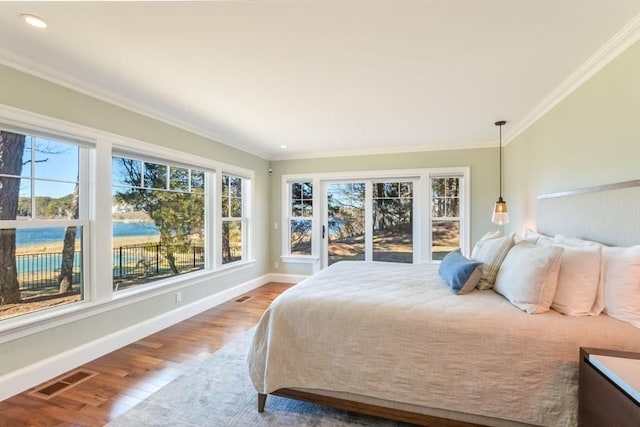 bedroom featuring baseboards, visible vents, ornamental molding, and wood finished floors