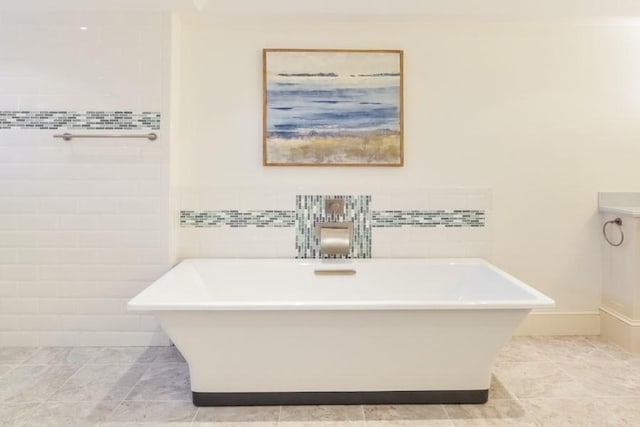 full bathroom featuring a soaking tub and tile walls