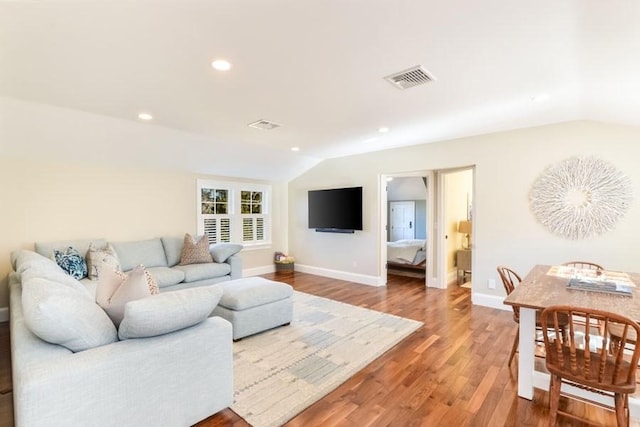 living room featuring recessed lighting, visible vents, vaulted ceiling, wood finished floors, and baseboards