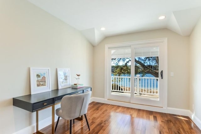 home office featuring lofted ceiling, hardwood / wood-style floors, and baseboards