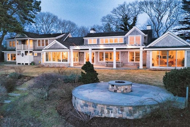 back of property with a patio area, an outdoor fire pit, and a chimney