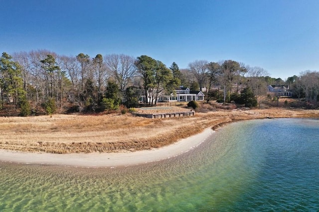 exterior space with dirt driveway and a water view